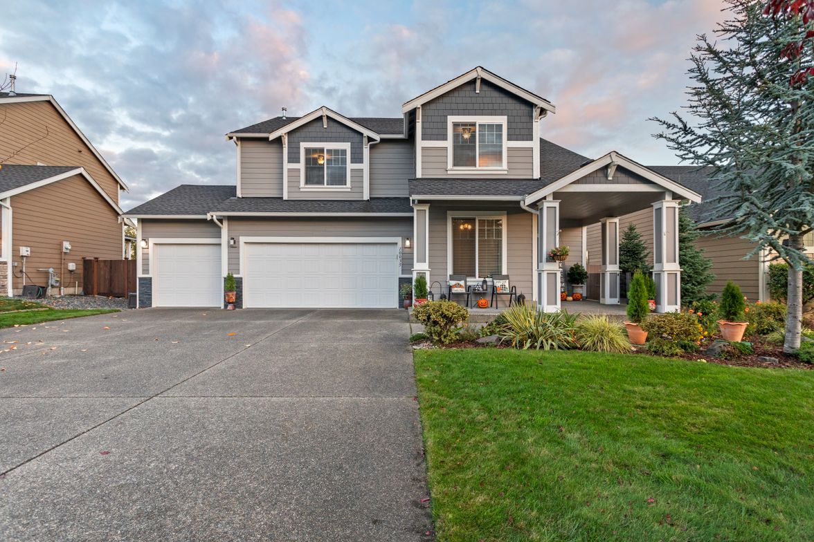Two-story house with an attached garage and a wide concrete driveway.